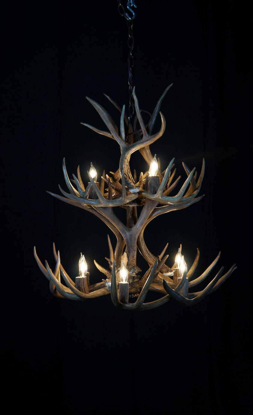 Large round elk antler chandelier hanging in a showroom